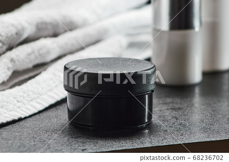 cosmetic black jar on a black table hair gel, bathroom .mocap, close up, copy space horizontal orientation cosmetic black jar on a black table hair gel, bathroom .mocap, close up, copy space horizontal orientation 68236702