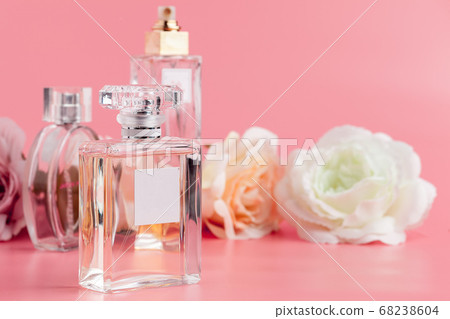 Perfume bottle with roses on pink fabric background 68238604