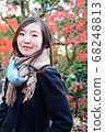 Woman posing in front of autumn leaves 68248813