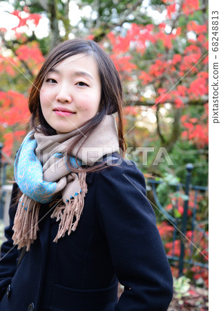 Woman posing in front of autumn leaves Woman posing in front of autumn leaves 68248813