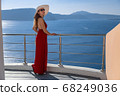 young woman enjoying view of Santorini, Greece 68249036