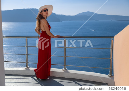 young woman enjoying view of Santorini, Greece young woman enjoying view of Santorini, Greece 68249036