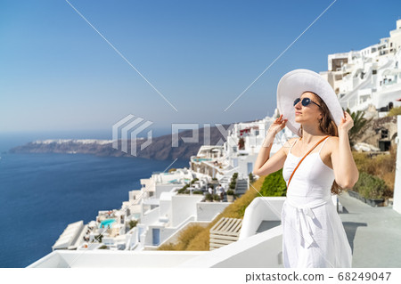 Europe Greece Santorini travel vacation woman on famous santorini Oia island travel destination. Happy young tourist woman. Summer wanderlust. Europe Greece Santorini travel vacation woman on famous santorini Oia island travel destination. Happy young tourist woman. Summer wanderlust. 68249047