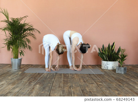 Smiling mother and daughter practicing yoga Smiling mother and daughter practicing yoga 68249143