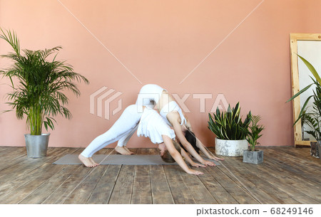 Smiling mother and daughter practicing yoga Smiling mother and daughter practicing yoga 68249146