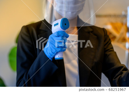 Female staff measuring temperature (state after corona) 68251967