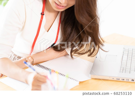 A young woman taking notes at desk work [Parts cut] 68253110