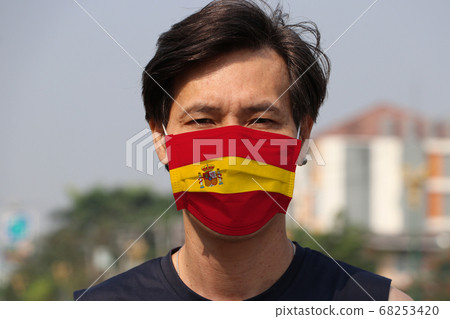 Spain flag on hygienic mask. Masked Asian man prevent germs.  68253420