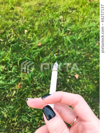 The hand of a smoking girl, a woman with beautiful The hand of a smoking girl, a woman with beautiful 68257137