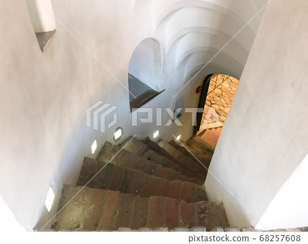 Steep stone spiral stairs going 68257608