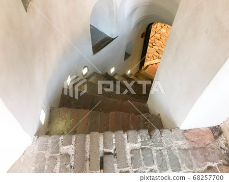 Steep stone spiral stairs going down 68257700