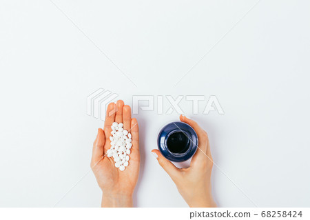 Woman's palm with handful of pills and hand 68258424