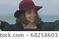 Beautiful girl in a red hat smiles, shows tongue and fooling around 68258603