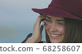 Beautiful girl in a red hat smiles, shows tongue and fooling around 68258607