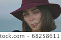 Beautiful girl in a red hat smiles, shows tongue and fooling around 68258611