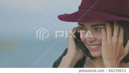 Beautiful girl in a red hat smiles, shows tongue and fooling around 68258615