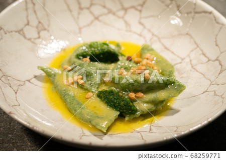 green ravioli with spinach and nuts in a plate green ravioli with spinach and nuts in a plate 68259771