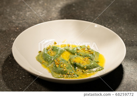 green ravioli with spinach and nuts in a plate green ravioli with spinach and nuts in a plate 68259772