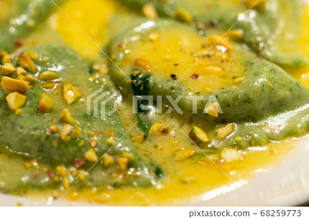 green ravioli with spinach and nuts in a plate green ravioli with spinach and nuts in a plate 68259773