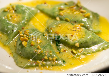 green ravioli with spinach and nuts in a plate green ravioli with spinach and nuts in a plate 68259775