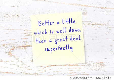 Yellow sticky note on wooden wall with wise quote 68261317