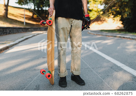 The guy is holding a board with red wheels. Skateboarding in the eternal city. The guy is holding a board with red wheels. Skateboarding in the eternal city. 68262875
