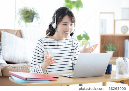 Young woman attending an online meeting at home Young woman attending an online meeting at home 68263900