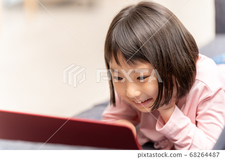 Girl using a laptop in the living room 68264487