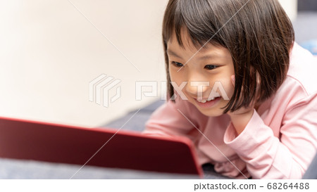 Girl using a laptop in the living room Girl using a laptop in the living room 68264488