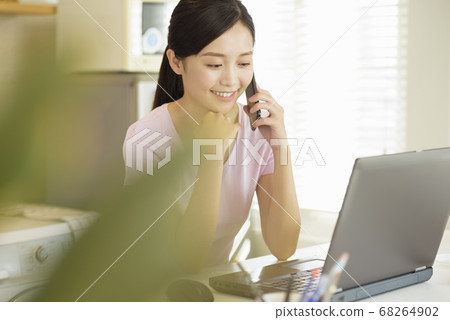 Business woman working at home with her laptop and smartphone 68264902