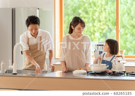 Girls and parents cooking food in the kitchen 68265185