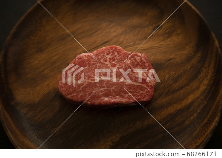 Raw beef fillet steak on acacia plate 68266171