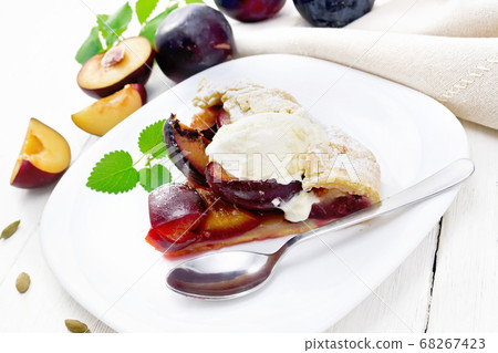 Galeta with plums in plate on white table Galeta with plums in plate on white table 68267423