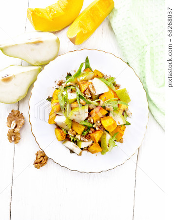 Salad of pumpkin and pear in plate on light board 68268037