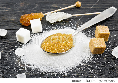 Sugar brown in spoon and white on black board 68268060