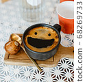 top view  smile face creama hot black coffee in black ceramic cup on wooden tray put white table with red plastic cups and glass bottle of water on white table, copy space, selective focused with nois 68269733