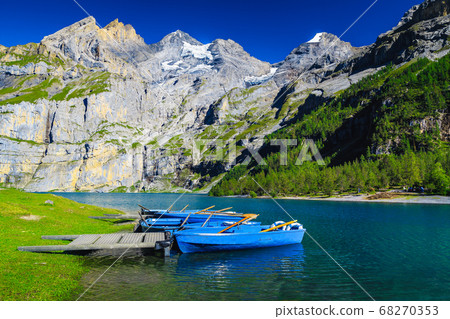 Anchored boats on the lake Oeschinensee, Bernese Oberland, Switzerland Anchored boats on the lake Oeschinensee, Bernese Oberland, Switzerland 68270353