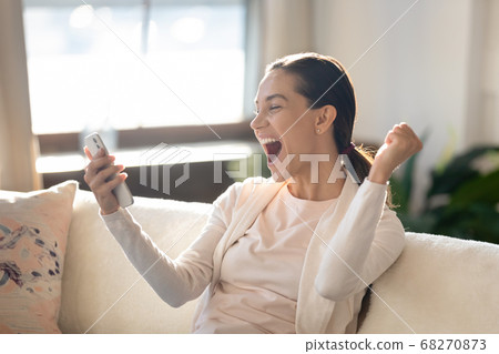 Overjoyed young girl looking at mobile screen, making yes gesture. Overjoyed young girl looking at mobile screen, making yes gesture. 68270873