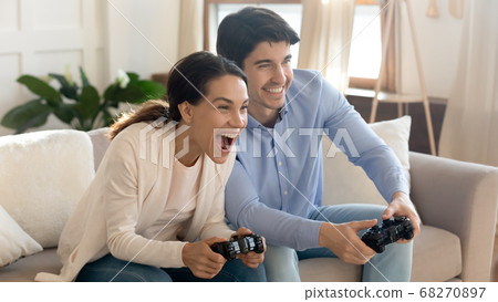 Emotional positive young loving family couple playing online video games. 68270897