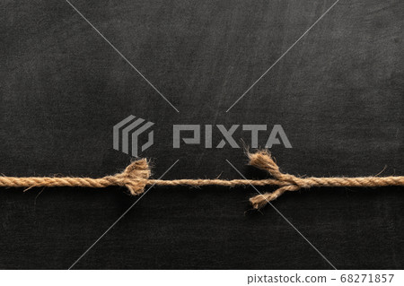 Long, old frayed rope is breaking off. Isolated on black. Long, old frayed rope is breaking off. Isolated on black. 68271857