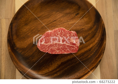 Raw beef fillet steak on acacia plate on wooden desk 68273222