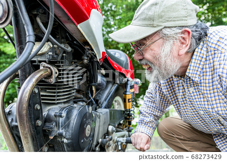 Bike life Senior rider maintaining a bike 68273429