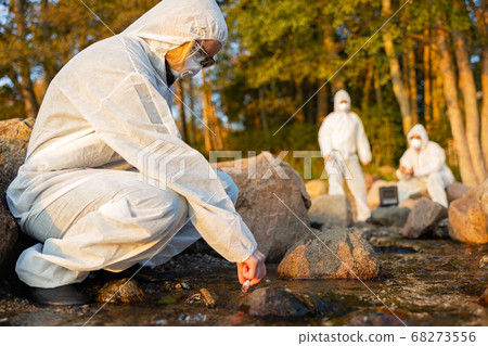 Female scientist collecting water sample from sea 68273556