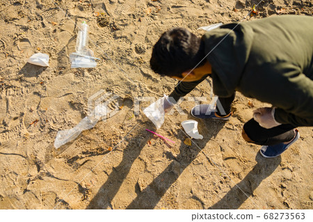Top view of volunteer protecting environmental and picking up garbage at beach Top view of volunteer protecting environmental and picking up garbage at beach 68273563
