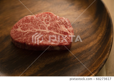 Raw beef fillet steak on acacia plate on wooden desk Raw beef fillet steak on acacia plate on wooden desk 68273617