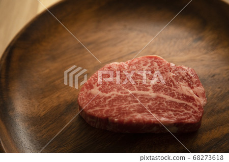 Raw beef fillet steak on acacia plate on wooden desk Raw beef fillet steak on acacia plate on wooden desk 68273618