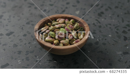 peeled pistachios in olive bowl on terrazzo surface peeled pistachios in olive bowl on terrazzo surface 68274335