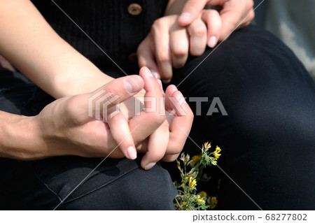 The male and female hand are holding each other. 68277802