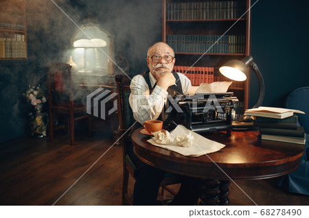 Elderly writer works on vintage typewriter 68278490