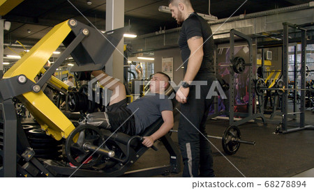 Young man with prosthetic leg using leg press machine in gym Young man with prosthetic leg using leg press machine in gym 68278894